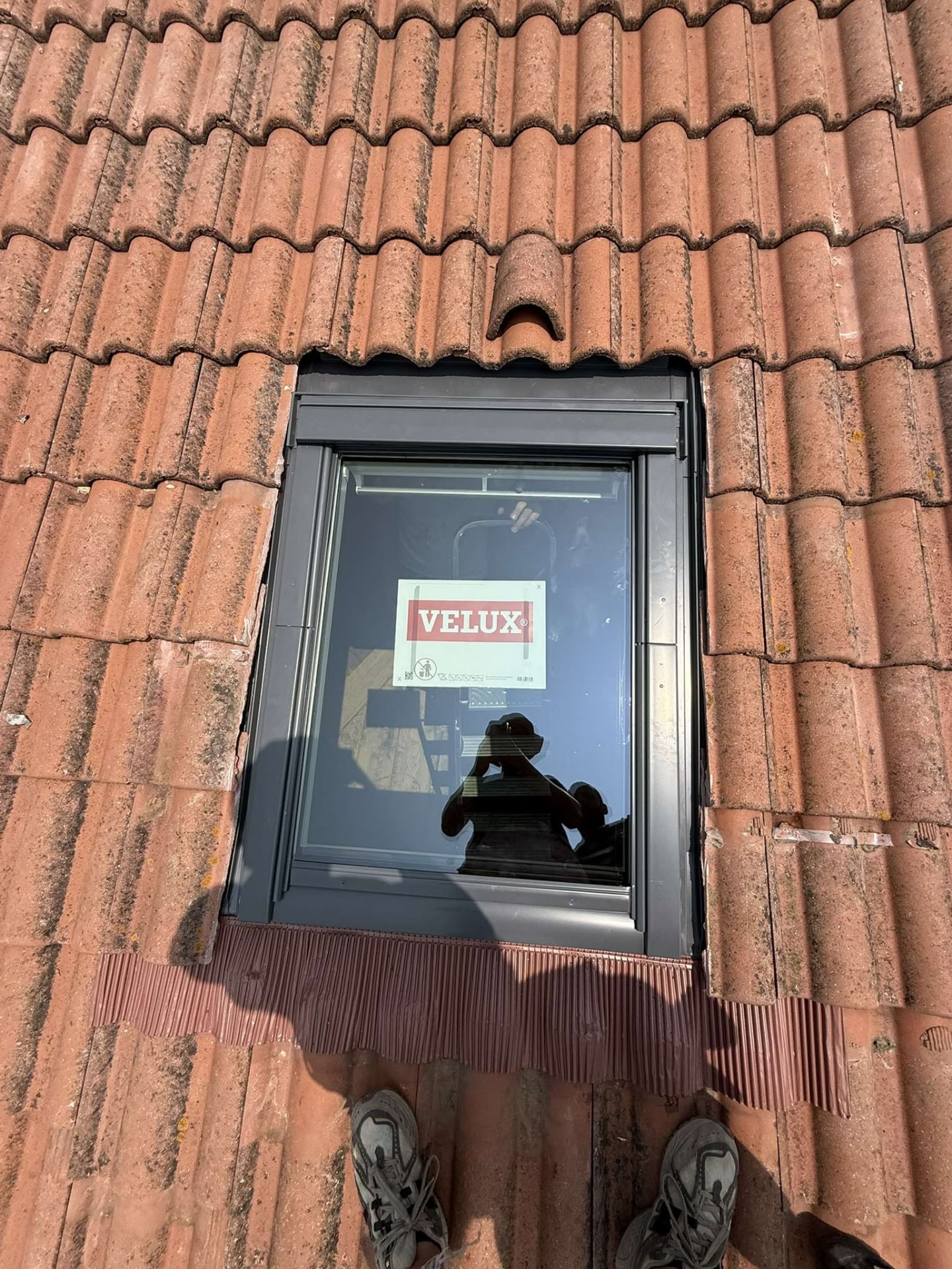 Fenêtre de toit Velux posée sur une toiture en tuiles rouges