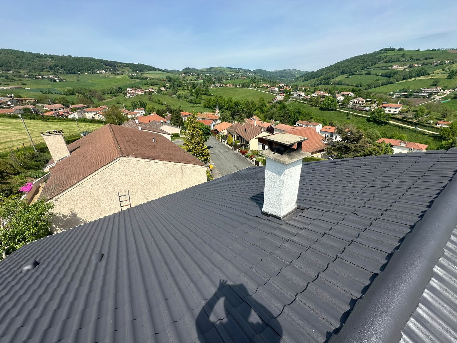 Toiture en tuiles anthracite après rénovation, vue sur les collines